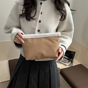 Pochette in finta pelle caramello con bordo in peluche bianco per lo stile invernale