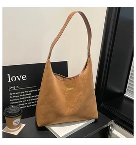 Detailed macro view of brown PU leather shoulder bag with golden fashion logo lettering