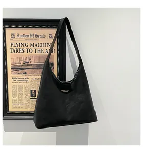 Detailed close-up of a black hobo shoulder bag with a gold logo and smooth leather texture