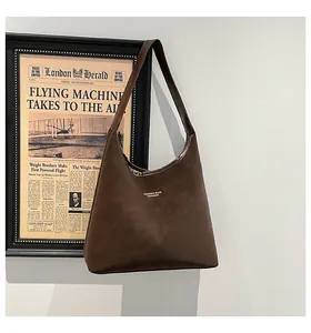 Detail of a deep brown retro Hobo shoulder bag with gold-embossed fashion lettering