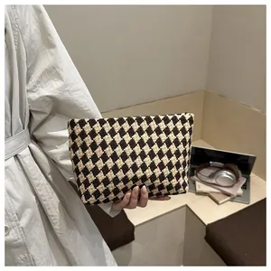 Close-up of knit checkered pattern texture on a luxury contrast color clutch bag