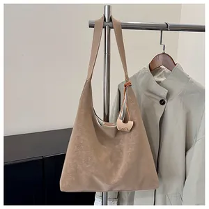 Dettaglio borsa hobo kaki in pelle vintage appesa a un appendiabiti in metallo