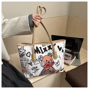 Dettaglio borsa tote in tela con graffiti e stampe colorate su tavolo in legno