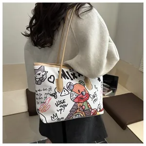 Dettaglio della borsa tote in tela con motivi graffiti vivaci e manici in ecopelle marrone