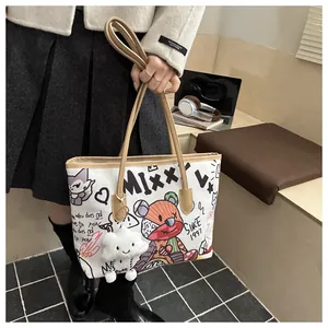 Borsa tote in tela graffiti con orsetto e ciondolo a nuvola portata da modella