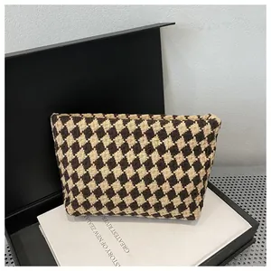 Detailed view of weave pattern on a brown and beige checkered luxury clutch bag