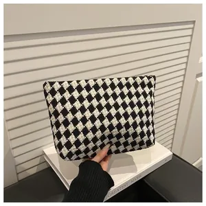 Close-up of the woven black and white houndstooth texture on this elegant evening clutch