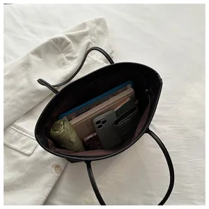 Interior view of large black tote bag showing spacious storage for a phone and notebooks