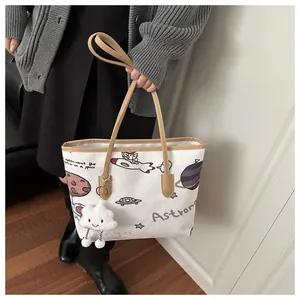Dettaglio della borsa tote in tela bianca con motivi spaziali e manici in cuoio