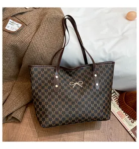 Détail du sac cabas d'hiver avec motif de lettres et nœud doré en métal décoratif