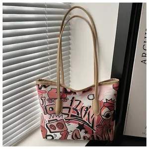 Dettaglio della borsa tote in tela rosa con graffiti, stampe retro e manici in pelle