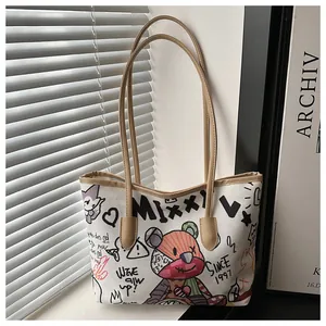 Dettaglio borsa tote in tela stile graffiti con stampa orsetto e manici in pelle