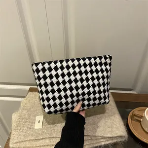 Chic black and white checkered knit clutch bag with a high-quality zipper closure