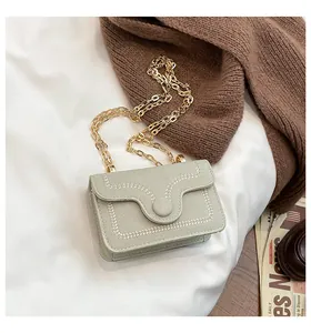 Close-up of elegant wheat stitching detail and gold chain strap on small crossbody bag