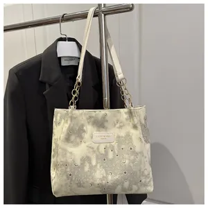 Dettaglio della borsa tote crema con stampa stelle e lune su espositore moda