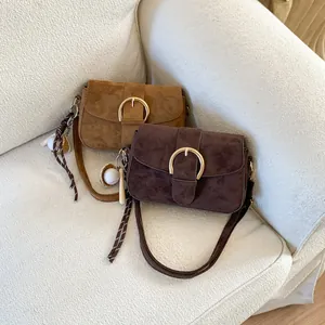 Detail view of retro crossbody bags with large gold rings and baseball charms