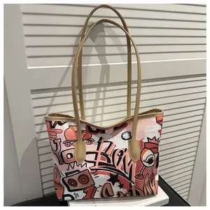 Dettaglio della borsa tote in tela con stampa graffiti e manici color cammello