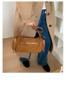 Detailaufnahme der camelfarbenen Wildledertasche mit Reißverschlüssen und matter Textur