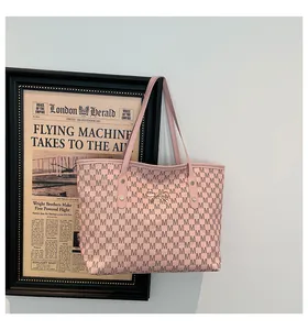 Sac fourre-tout rose avec motif M, pendentif nœud doré et doubles bandoulières chic