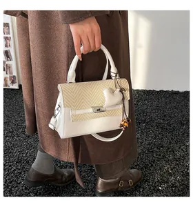 Detail of a chic plaid small square bag with silver rotary lock and heart pendant