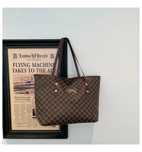 Vue détaillée du sac cabas rétro marron avec texture à motif M et nœud doré élégant
