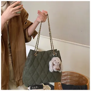 Detail van de bosgroene gewatteerde shopper met gouden ketting en pluche konijn hanger
