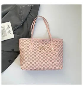 Détails du sac cabas rose avec imprimé M et décoration nœud rose en métal sur fond blanc