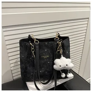 Dettaglio borsa tote nera con stampa stelle e luna e ciondolo a nuvola di peluche