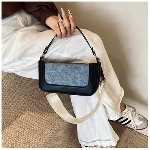 Detail of color-block small square bag with gray-blue felt flap and wide crossbody strap