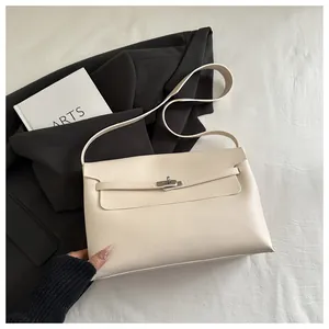 Dettaglio borsa a mano minimalista in pelle crema con fibbia argento e tracolla