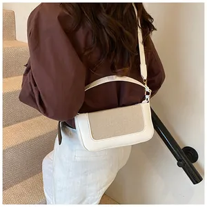 Minimalist beige woven fabric handbag with white leather trim shown on a model