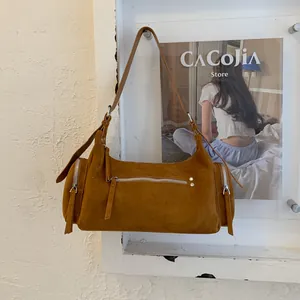Detail der braunen Wildlederstruktur einer Vintage-Zylindertasche mit Nietenbesatz