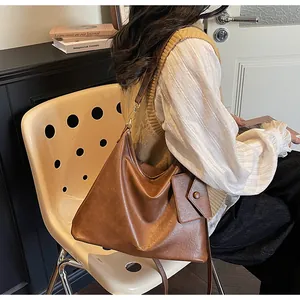 Dettaglio della borsa tote vintage marrone in pelle PU con pochette e logo dorato fine