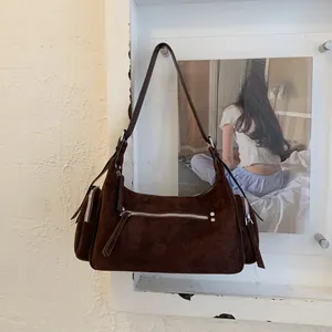 Detailansicht der braunen Wildledertasche mit silbernen Reißverschlüssen im Industrial-Stil