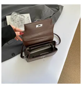 Detailed interior of a dark brown leather bag with functional zipper layers and silver hardware