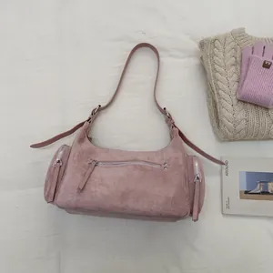 Detailansicht der altrosa Wildledertasche mit Reißverschlussfächern auf hellem Stoff