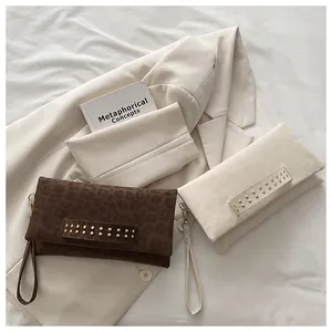 Detalle de bolsos de mano de leopardo en terciopelo con remaches dorados y correas