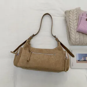 Nahaufnahme der camelfarbenen Wildledertasche mit Silberreißverschlüssen und Trageriemen