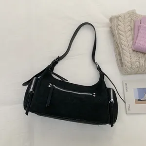 Draufsicht auf schwarze Wildleder-Schultertasche mit silbernen Reißverschlüssen und Nieten