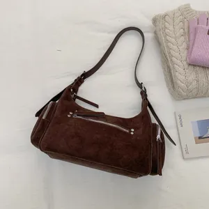 Detailansicht der braunen Wildlederhandtasche mit Metallreißverschlüssen und Nieten