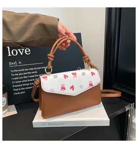 Close-up of a structured square crossbody bag with printed bear motif and knot handle