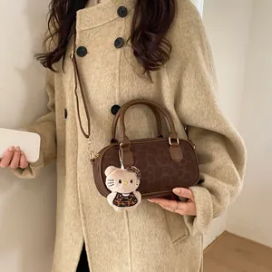 Detail of leopard print brown leather bag with cartoon plush pendant on beige coat