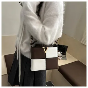 Detail of contrast color square handbag with lychee pattern and gold V hardware