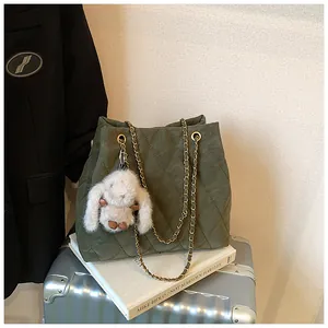 Detail van donkergroene gewatteerde shopper met gouden ketting en schattig konijntje