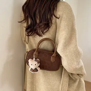 Brown leopard print Boston bag styled with a plush charm on a beige coat outfit