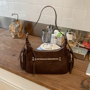 Detailansicht der dunkelbraunen Wildleder-Schultertasche mit silbernen Reißverschlüssen
