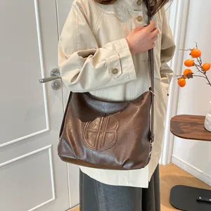 Minimalist dark brown oversized faux leather shoulder bag with vintage texture and round logo