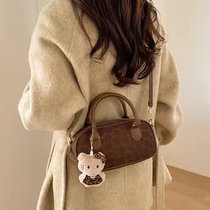 Detail of leopard print handbag with plush charm and long strap on beige wool coat