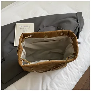 Detailweergave van het ruime binnenvak en de gouden ketting van de gewatteerde draagtas