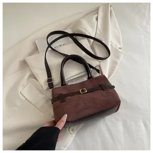 Détail du sac à main marron foncé avec boucle de ceinture et textures bi-matière